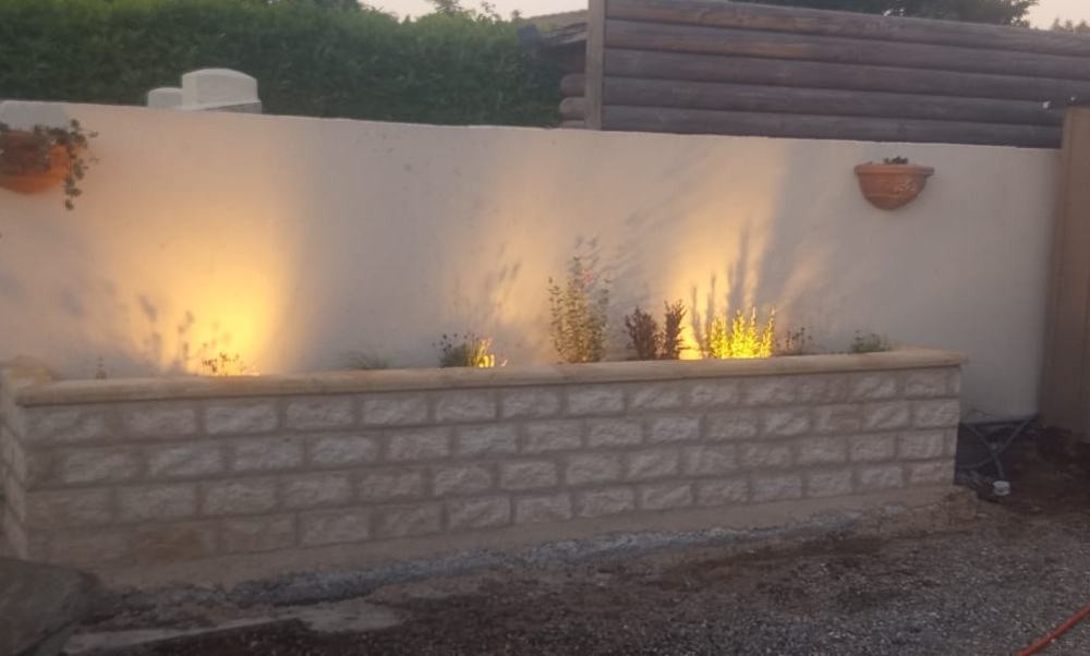 Jardinière maçonnée éclairée le long d'un mur enduit