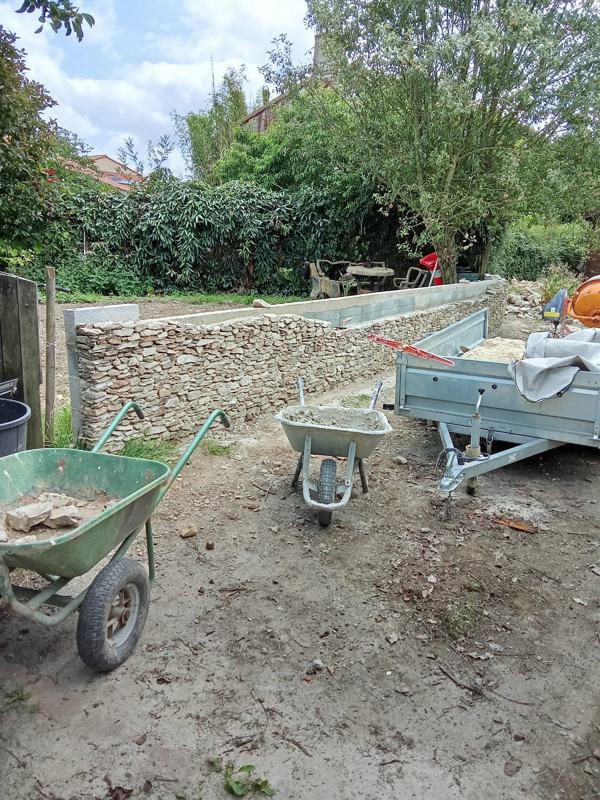 Muret de jardin en parement de pierre en cours de montage